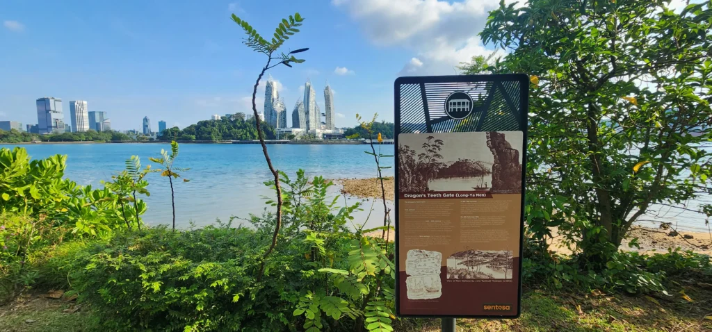 Dragon’s Teeth Gate marker in Sentosa with coastal view and Singapore skyline in the background