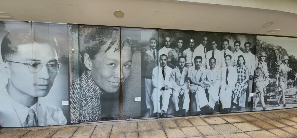 Black and white historical mural at Fort Siloso showing people and scenes from Singapore’s past