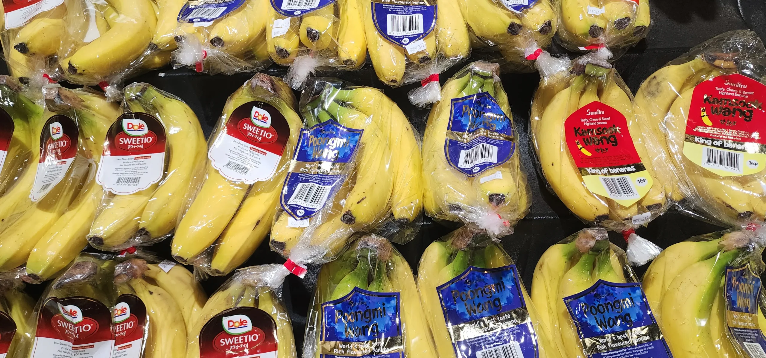 Packaged bananas displayed for sale at a supermarket produce section