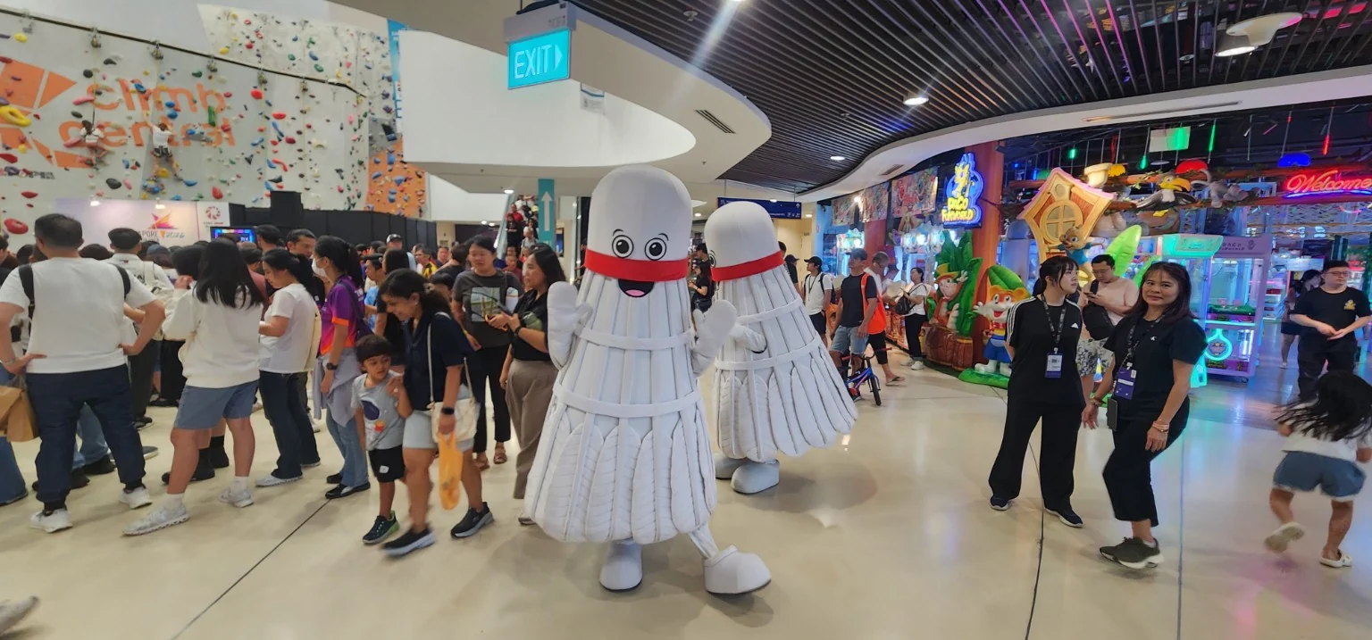 Family-friendly mascot area with spectators at the KFF Singapore Badminton Open 2026