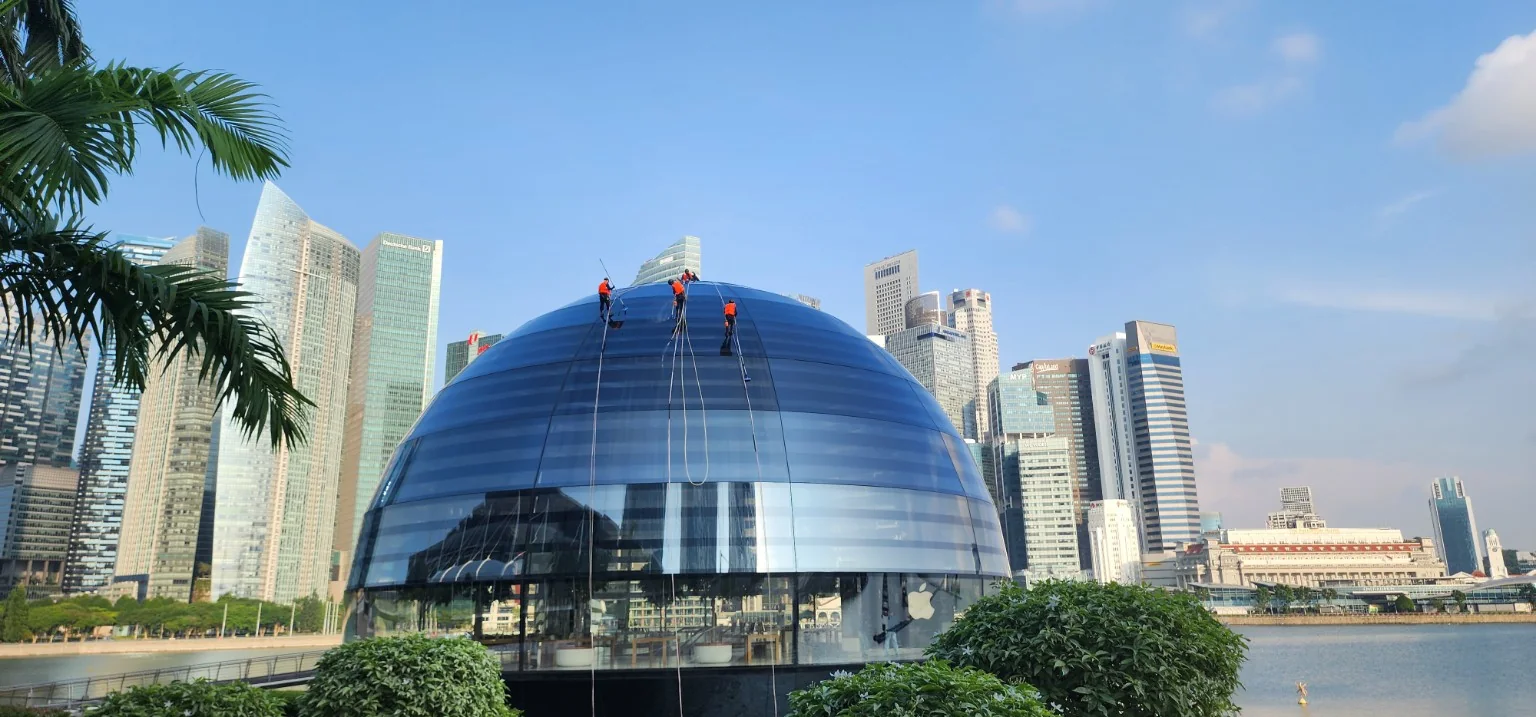 Apple Marina Bay Sands glass dome with the city skyline behind it