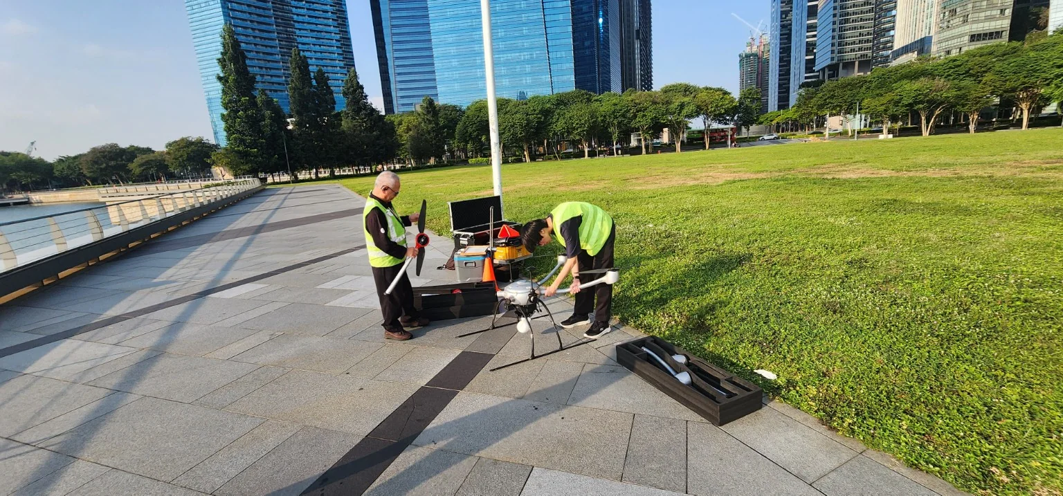 Technical crew preparing drone equipment beside Marina Bay