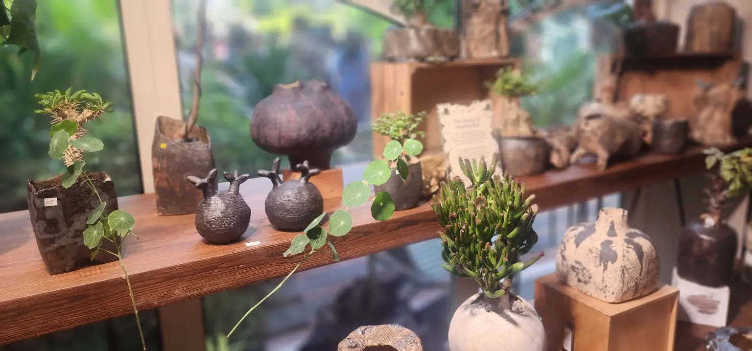 Handmade sculptural plant vessels displayed beside the garden windows at GREEN-HOUSE Festival 2026