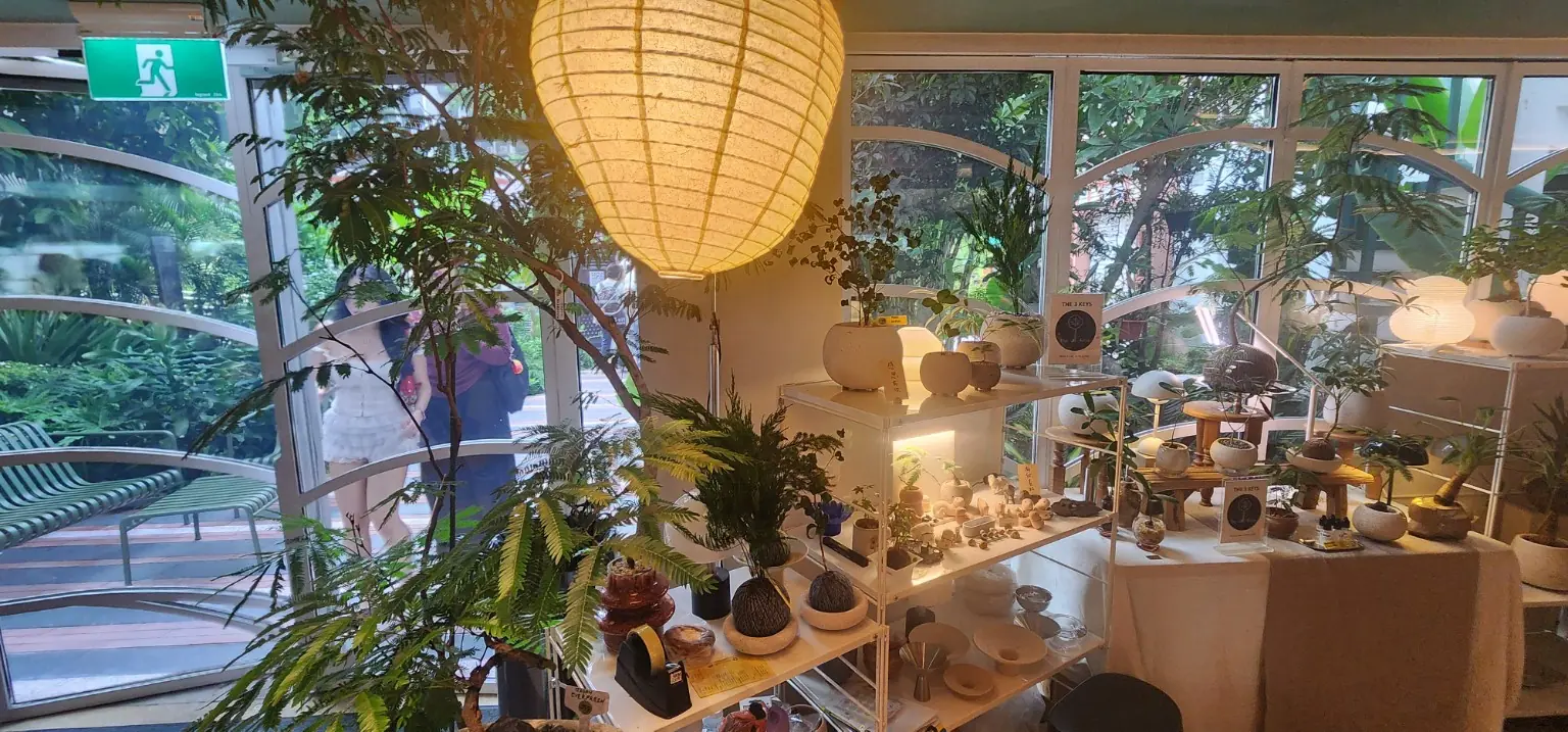 Plants and ceramics displayed beside garden-facing windows at GREEN-HOUSE Festival 2026