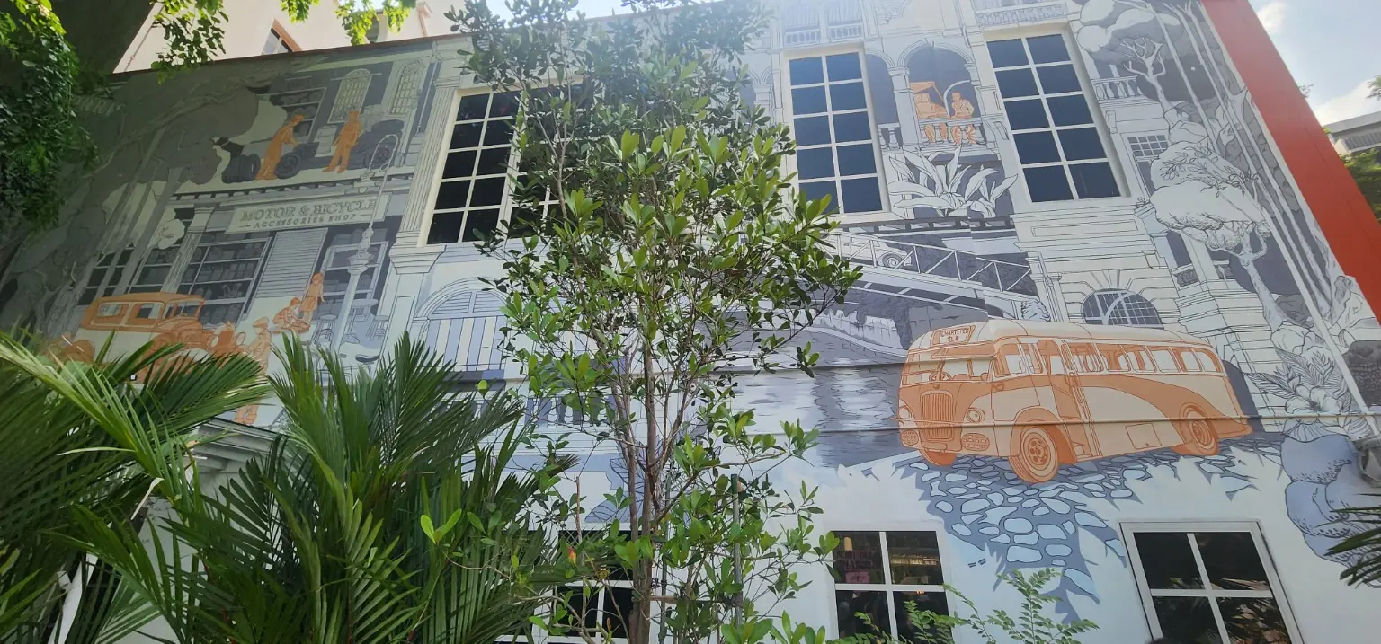 Heritage mural depicting earlier Dhoby Ghaut street life beside the Temasek Shophouse garden