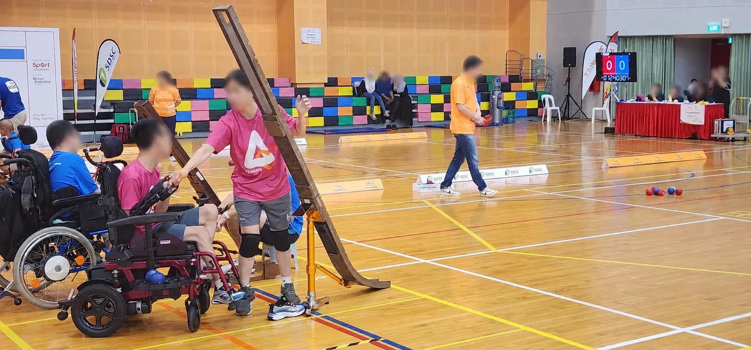 Boccia athlete directing a ramp operator during a competitive delivery