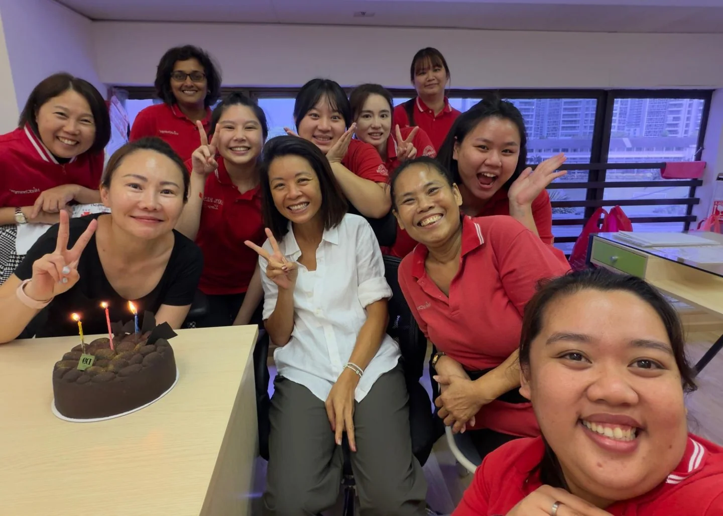 Jocelyn Goh with educators during a team celebration around a birthday cake